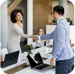 Two smiling professionals shaking hands in a bright office meeting, building Investor Confidence for a new venture.